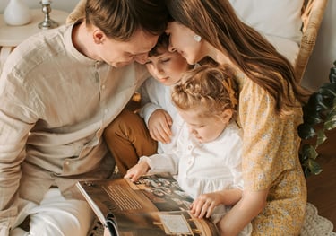 a family of three children sitting on a bed
