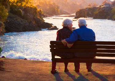 a couple sitting on a bench in front of a river. RRSP Account. Retirement Planning