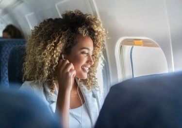 Persona mirando por la ventanilla del avión con expresión calmada, transmitiendo serenidad durante e