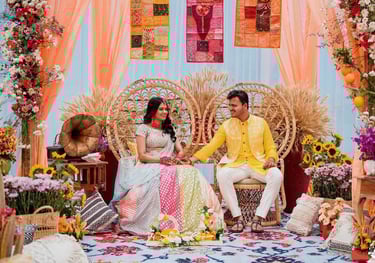 a couple sitting on a couch in a room with a floral arrangement