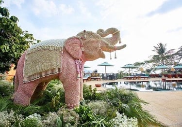 a pink elephant statue in a garden