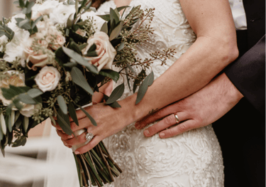 a bride and groom holding a bouquet of flowers