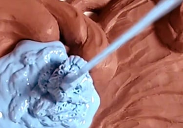 Pic of the custom mold making process. A stream of blue silicone poured over a clay sculpture