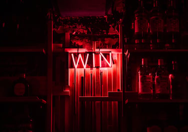 a wine bar with a neon light sign red written 'WIN'. - Swrill