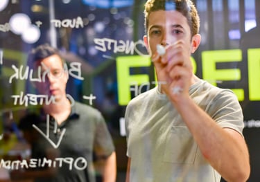 a man holding a marker in front of a transparent glass writing board - Swrill