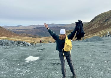 Coach Moll facing a mountain view with arms raised