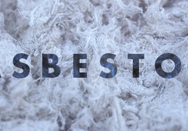 a pile of asbestos and a sign that says asbestos to us