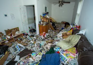 a messy hoarders living room with a couch and a couch