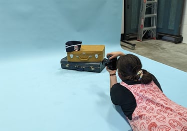 Laura photographs a set of vintage suitcases on a blue backdrop for Closet Mod in an Adelaide