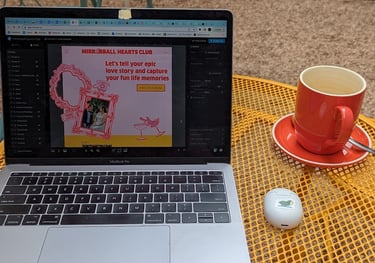 A laptop open to Show It website builder. Mirrorball Hearts Club is being designed on screen.