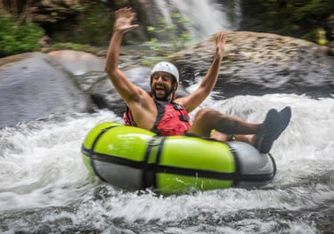 a man is riding a tube in a river