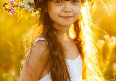 a young girl wearing a flower crown in a field