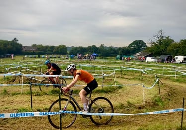 a cyclist riding a bike around a corner on a cyclocross course
