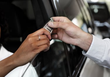 auto1Locksmith standing outside the car giving Man setting in a car his new key