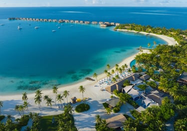 a beach with a boat in the water, waldorf astoria maldives