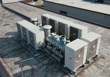 An aerial view of a large-scale supermarket roof showing modern HVAC and refrigeration compressors, crisp professional drone photography.