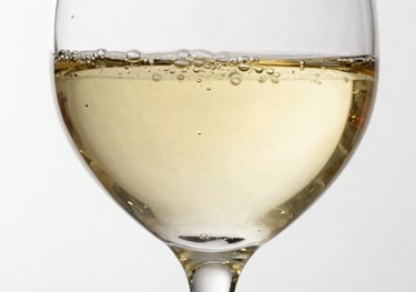 Elegant studio shot of a Sauvignon Blanc glass, vibrant pale yellow liquid with micro-bubbles, clean and refreshing look on white background.