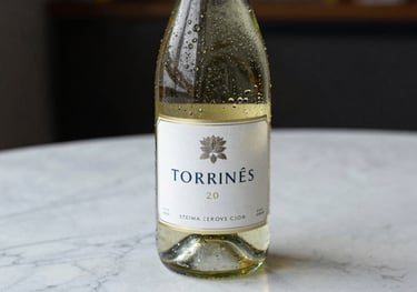 A bottle of Torrontés wine standing on a white marble table, droplets of condensation on the glass, bright and fresh aesthetic.