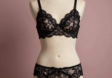 Studio photography of an elegant black lace lingerie set displayed on a mannequin, soft directional lighting, muted rose background, high-end professional catalog style.