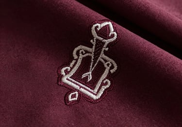 Detailed close-up of premium silk fabric and delicate embroidery in dark wine color, North American and European aesthetic, emphasizing textile quality.