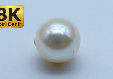 Macro shot of a pearl's surface under a soft light, showing a clean and smooth texture with almost no visible imperfections. Background in Soft Pearl Blue.