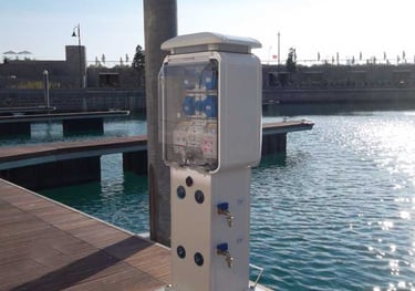 Colonnina elettrica marino bianco e stazione idrica situati su un molo in per barche in un porto