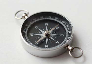 A minimalist photo of a compass on a clean surface, representing strategic direction and intentional grantmaking. Palette includes #1A1A1A and #F8F4F0.