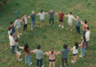 An aerial view of a group of people standing in a circle holding hands in a park, representing community and unity. The image features colors like #3D5B5F and #A2B2AE.