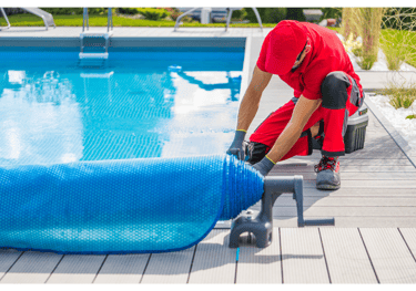 Image of a pool tech preparing a pool closing by rolling out the pool cover