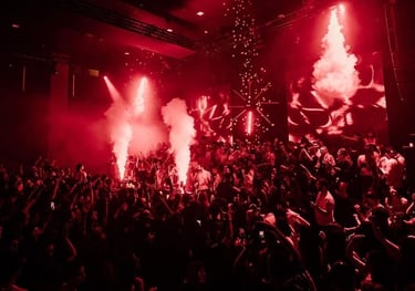 a crowd of people standing around a stage with red lights