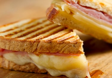 a sandwich sandwich with cheese and ham on a wooden board