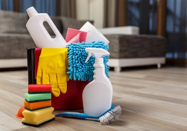 a bucket full of cleaning supplies on a wooden floor