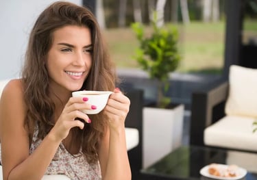 Mulher sorridente tomando chá saudável ao ar livre, promovendo bem-estar e hábitos saudáveis