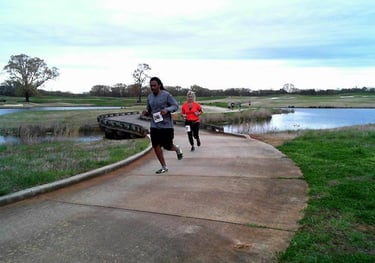 A photo of runners racing acoss a bridge at the Rober Trent Jones Running the Shoals Marathon