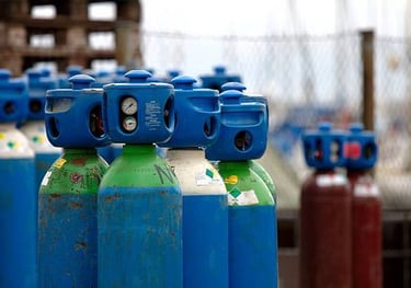 a row of gas bottles with gas cylinders