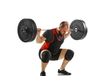 Professional powerlifter performing a heavy barbell back squat exercise on a white background.