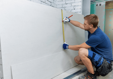 a man is measuring a wall with a tape measure tape