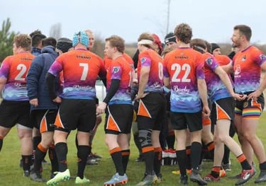 a group of rugby players huddle around a field during their tournament