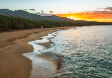 a beach with a sunset in the background