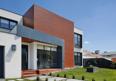 a house with a large brick wall and a large window