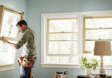 a man in a window sill holding a window