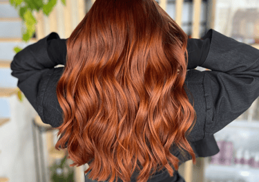 une femme aux cheveux roux et au haut noir