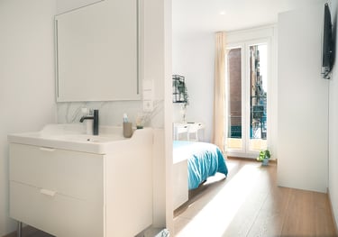 "Un baño con un lavado y una cama dentro."