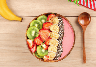 "Un tazón de frutas y una cuchara en él."