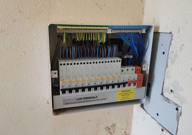 Open consumer unit showing circuit breakers and electrical wiring in a modern fuse box.