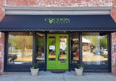 The Cocoon Gallery storefront features lime green doors and a black awning over artisan craft displays.