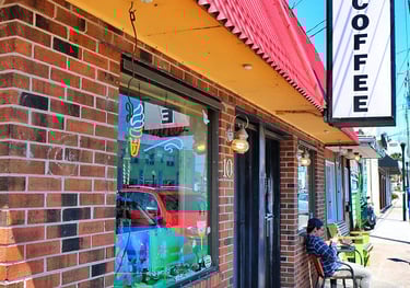 Majik Beanz Espresso coffee shop with brick exterior and outdoor sidewalk seating.