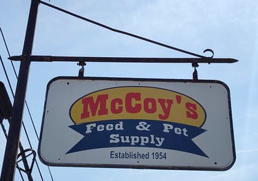 Vintage hanging sign for McCoy's Feed & Pet Supply established in 1954.