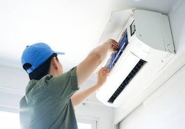 a man in a blue hat is fixing a air conditioner
