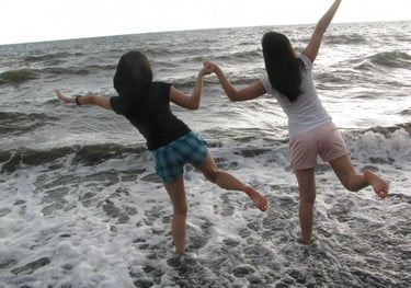 young girls dancing on the beach